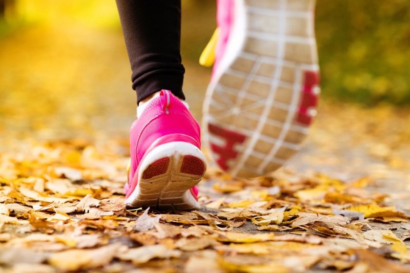 up close of pink shoes running through fall leaves Columbus races